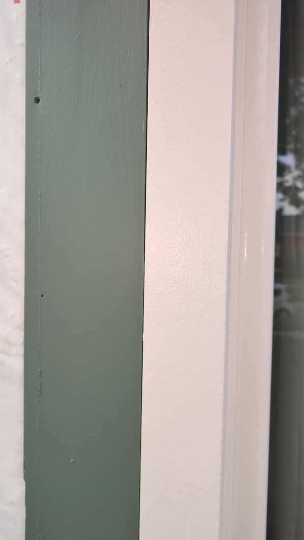 Primer on the porch column, beside the old green trim. The stripped sides took two coats before paint.