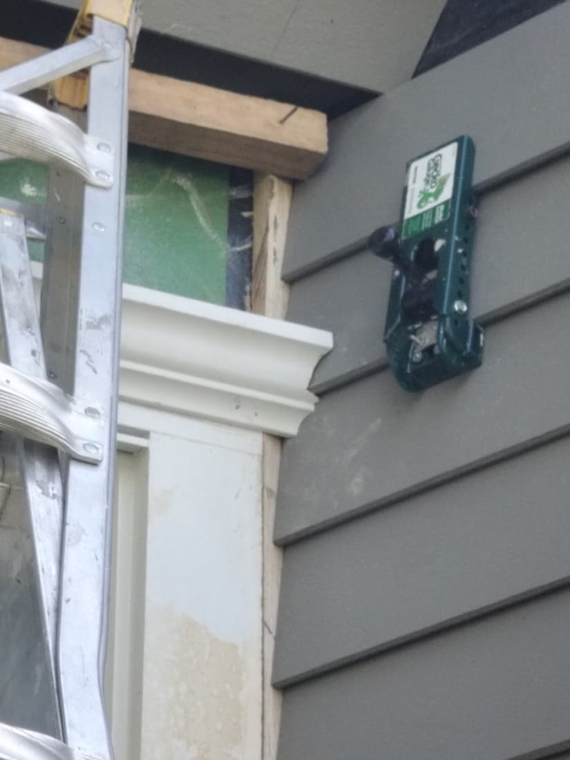 A finished cornice over a window, with the siding run up to it and the gauge still hung on the wall.