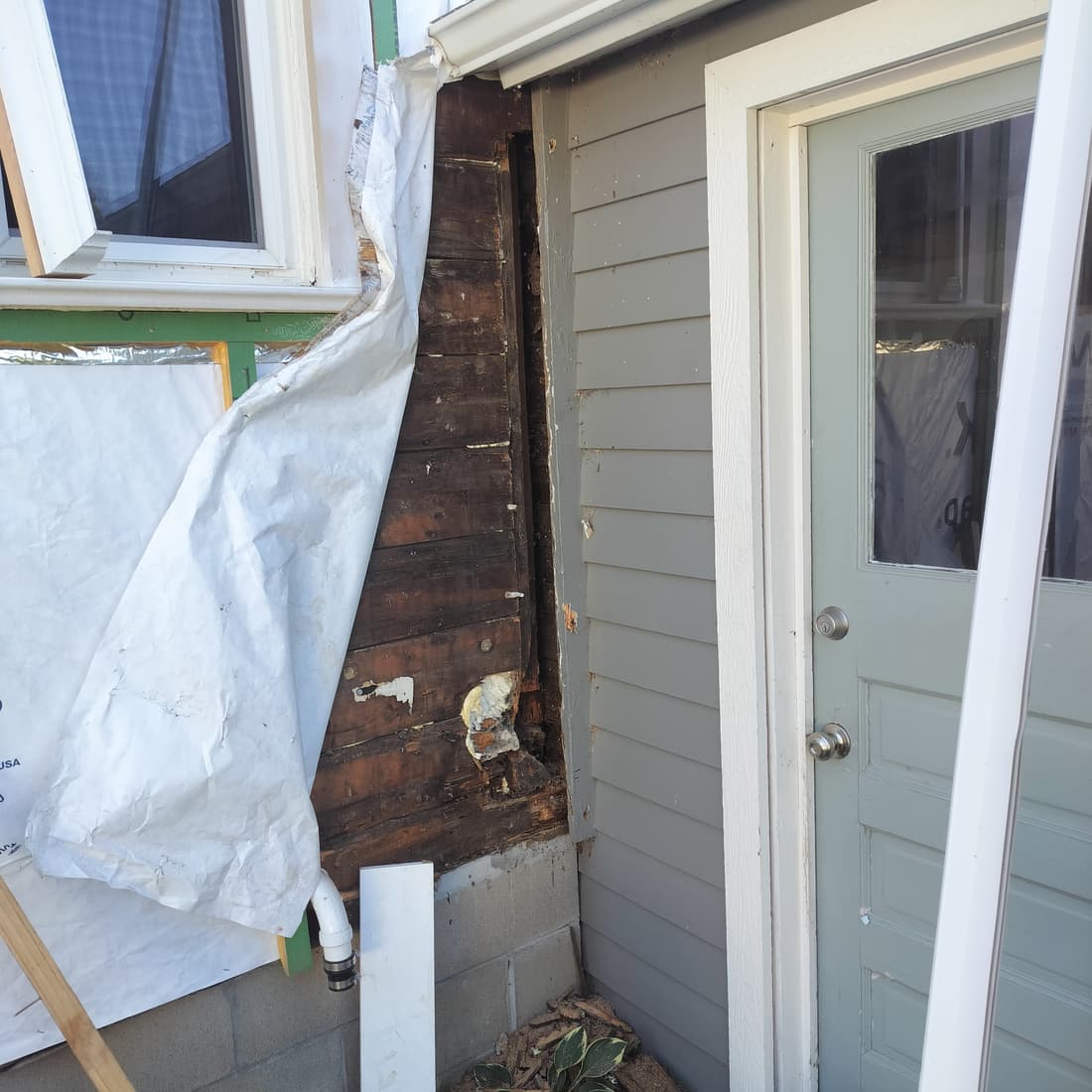 The same corner from the door side, with the old sheathing exposed.