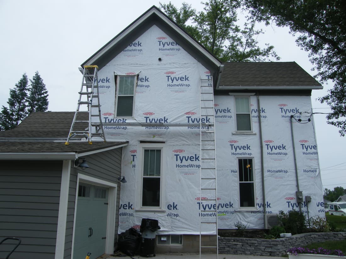 The west wall wrapped, with the old siding gone.