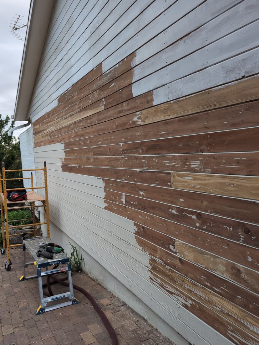 The east wall part way through the paint shave, down to bare redwood.
